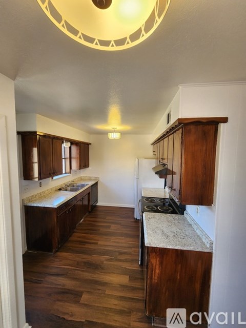 A kitchen with wooden cabinets and a marble countertop.