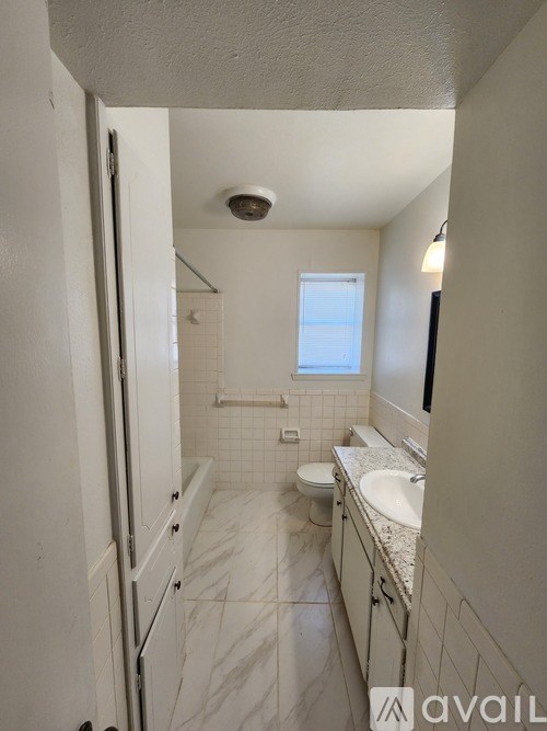 A bathroom with a toilet, sink, and shower.