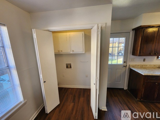 A room with a white door and a window with blinds.