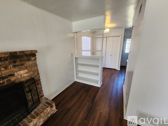 A room with a fireplace and a window with blinds.
