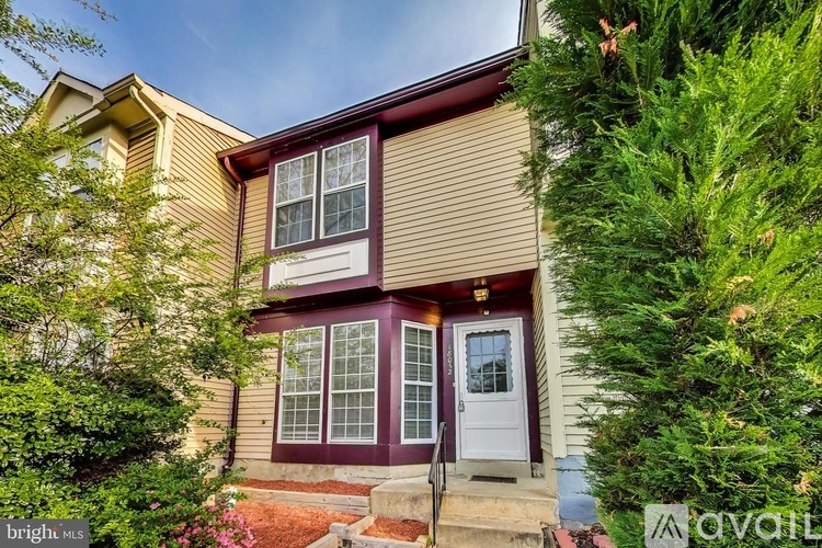 A house with a red door and a white window is for sale.