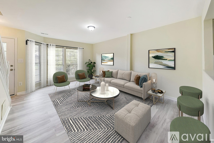 A living room with a grey sofa, green armchairs, and a patterned rug.