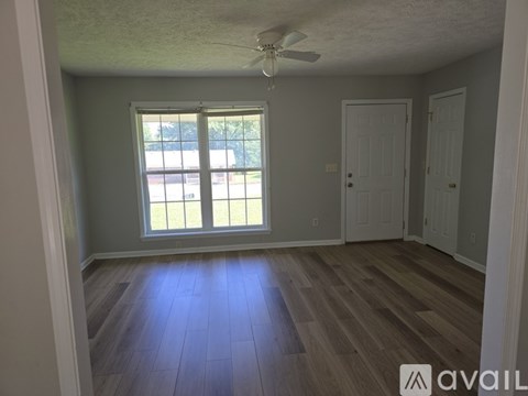 A room with a window and a ceiling fan.