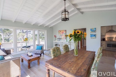 A sunny day in a spacious living room with a wooden table and chairs.