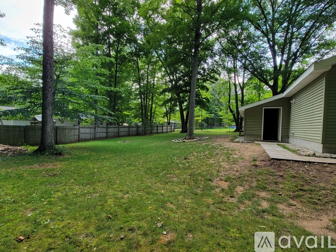 A backyard with a fence and a shed.