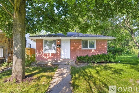 A brick house with a white door and windows is for sale.
