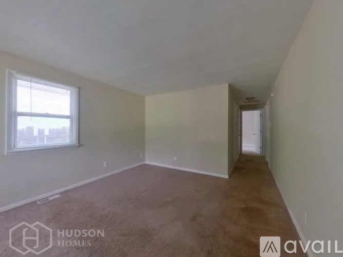 A room with a window and carpeted floor is available for rent.