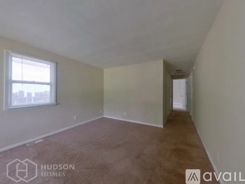 A room with a window and carpeted floor is available for rent.