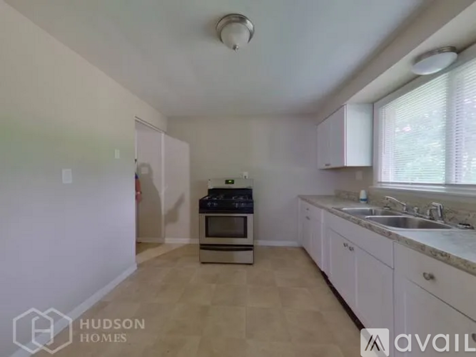 A kitchen with white cabinets and a stove top oven.
