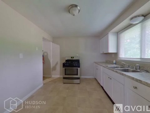 A kitchen with white cabinets and a stove top oven.