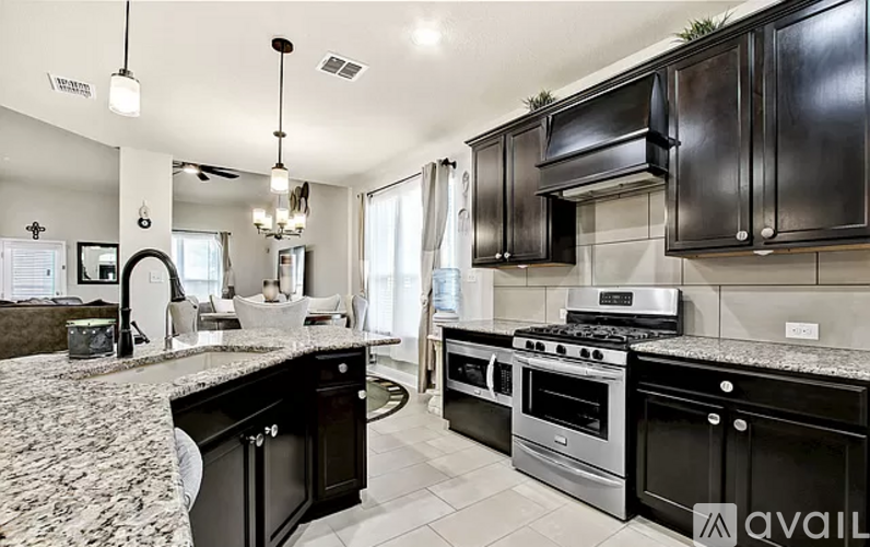 A modern kitchen with black cabinets and granite countertops.