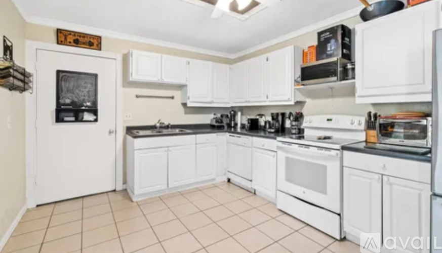 A kitchen with white appliances and cabinets.