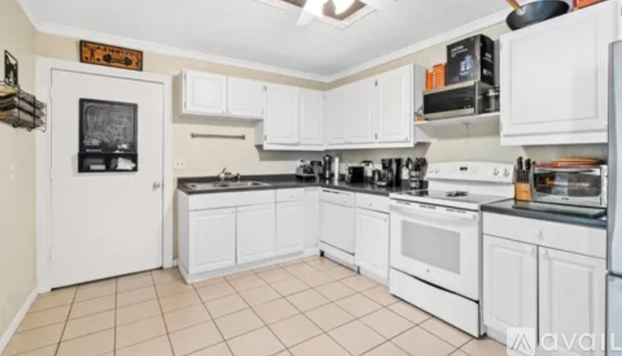 A kitchen with white appliances and cabinets.