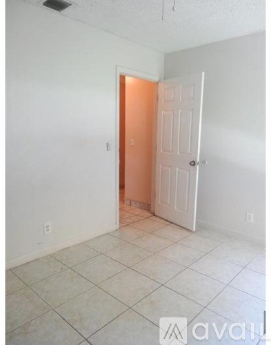 A room with a white door and a white wall.