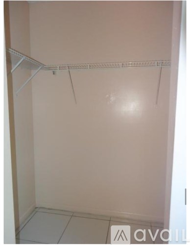 A white closet with a white shelf and a white floor.
