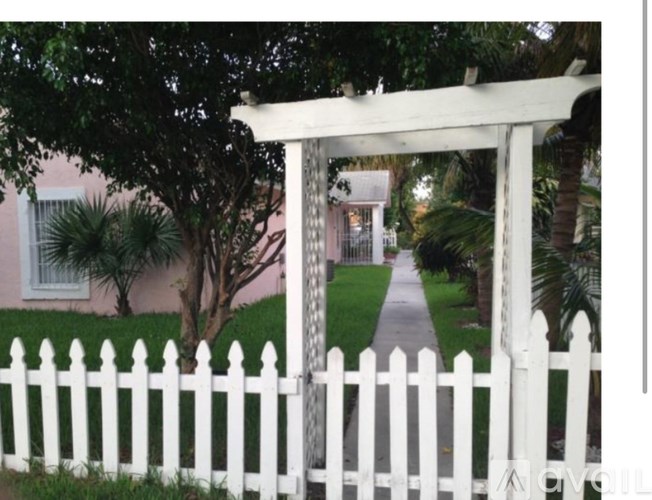 A white picket fence in front of a house.