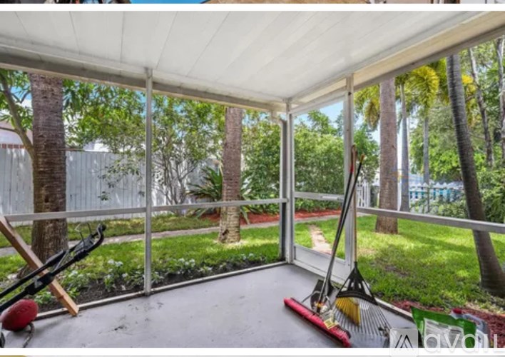 A patio with a white awning and a red broom.