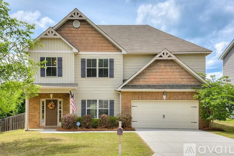 A two-story house with a garage and a front yard.