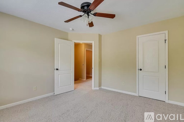 A room with a ceiling fan and two doors.