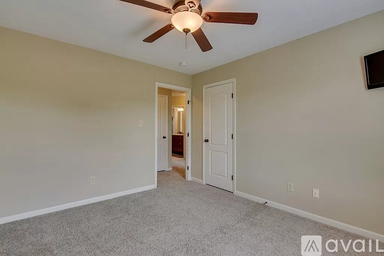 A room with a ceiling fan and a carpeted floor.