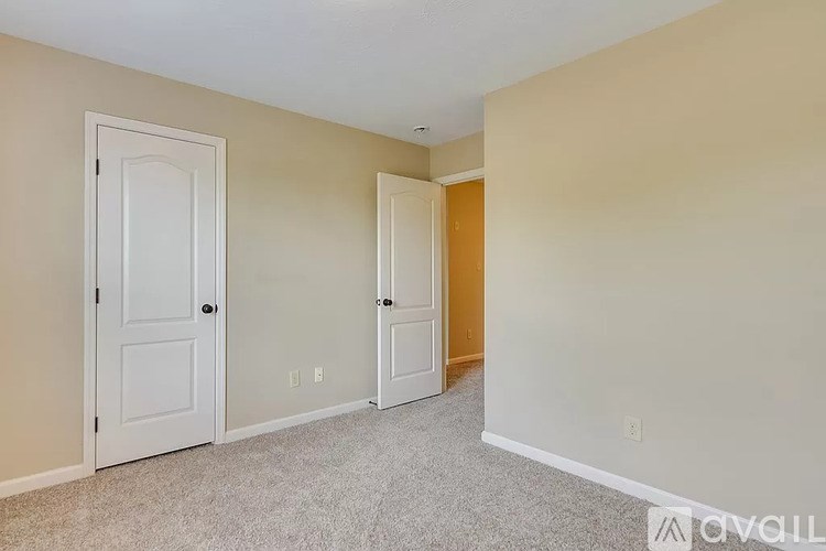 A room with two doors and a carpeted floor.