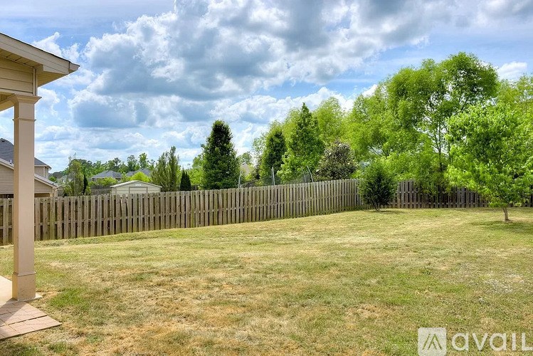 A backyard with a wooden fence and trees.