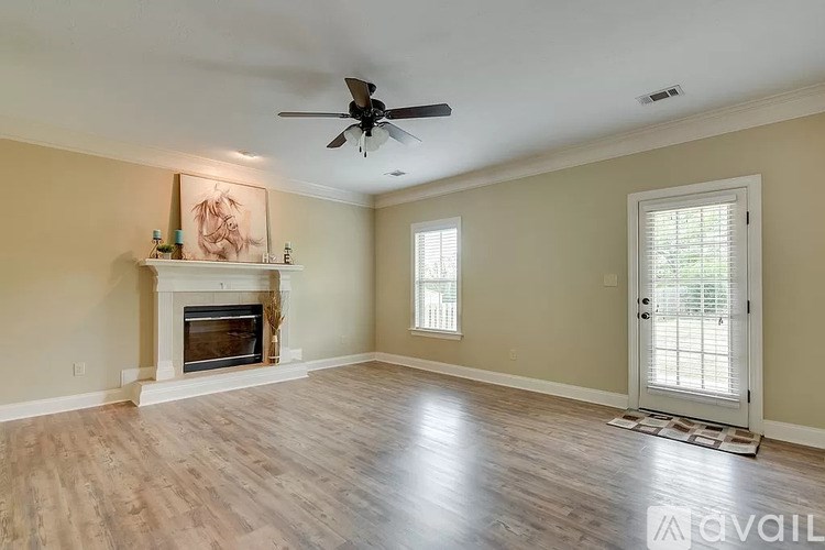 A spacious room with a fireplace and a ceiling fan.