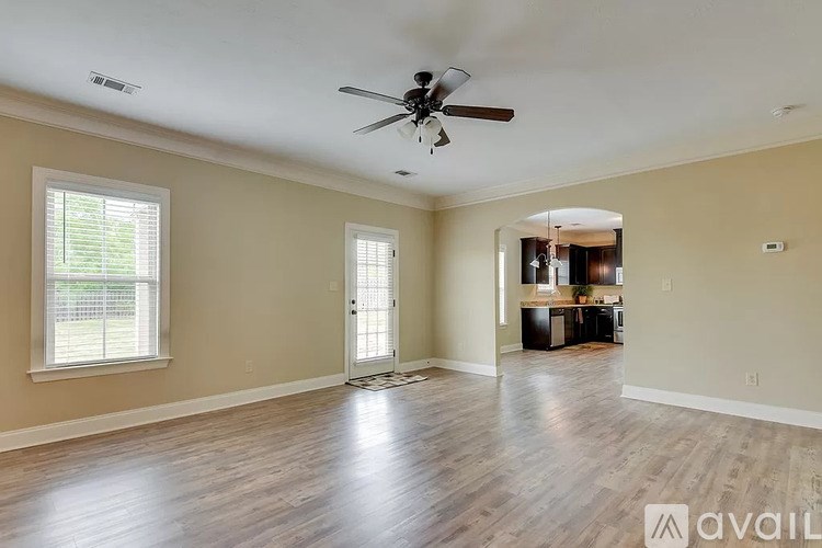 A spacious room with a ceiling fan and wooden flooring.