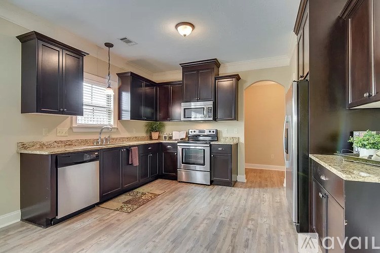 A kitchen with dark brown cabinets and stainless steel appliances.