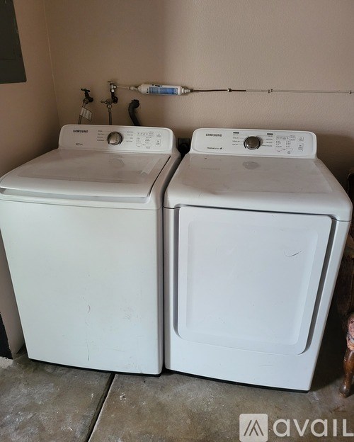 Two white front loading washing machines in a laundry room.