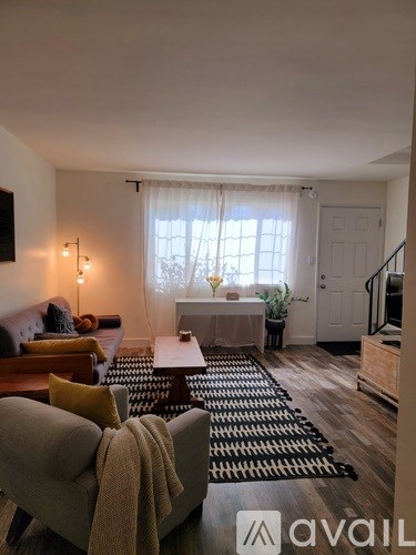 A living room with a couch, a coffee table, and a rug.