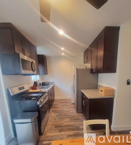 A kitchen with dark wood cabinets and a stainless steel refrigerator.