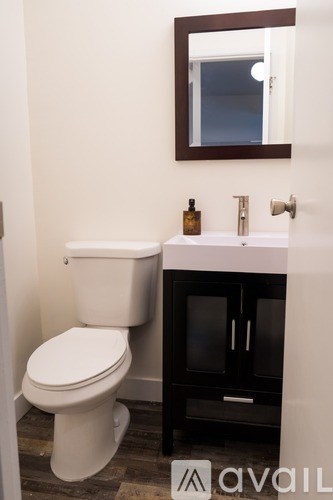 A white toilet sits next to a sink in a bathroom.