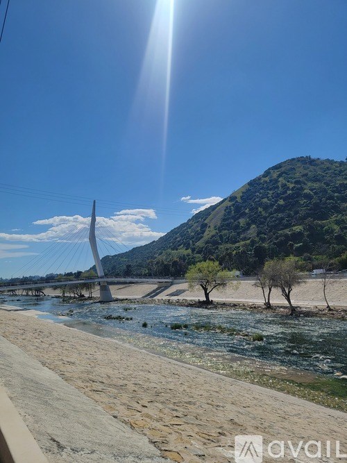 A bridge over a river with a mountain in the background.