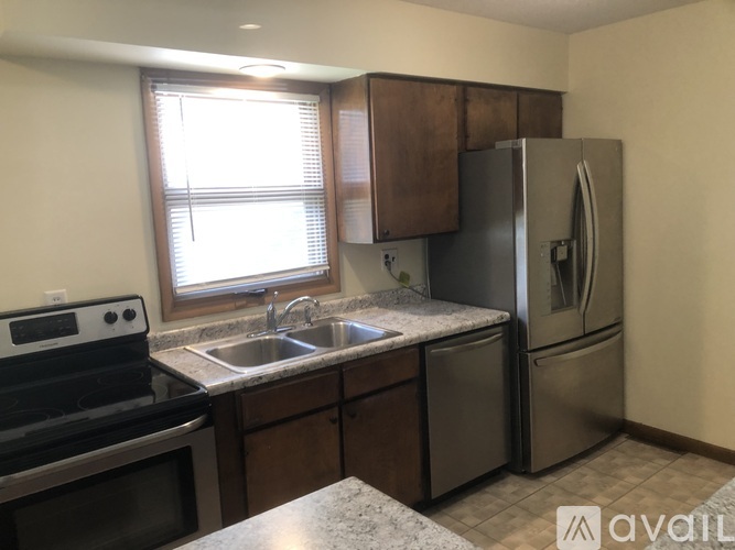 A kitchen with a stove, sink, and refrigerator.