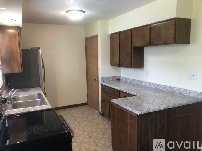 A kitchen with a black stove top oven and a granite counter top.