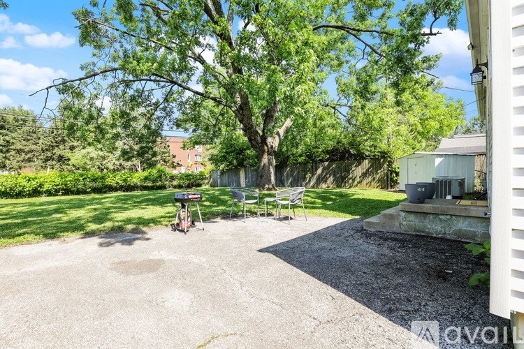 A backyard with a gravel area, a tree, and a picnic table.