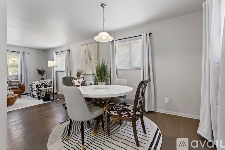 A dining room with a white table and chairs.