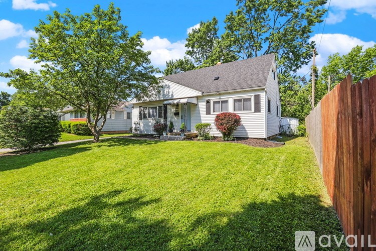 A house with a lawn and a tree in front of it.