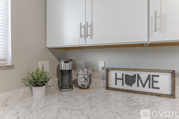 A kitchen counter with a sign that says "HOME" and a plant on it.