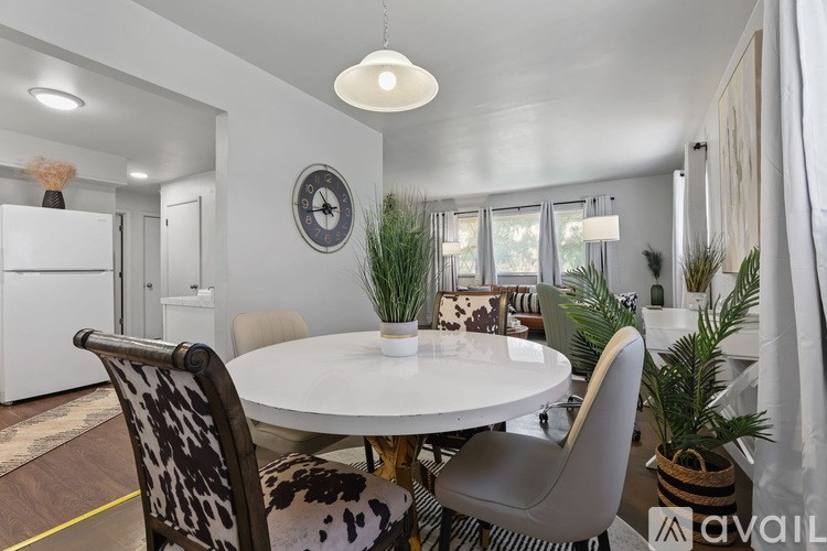 A modern dining room with a white table and chairs.
