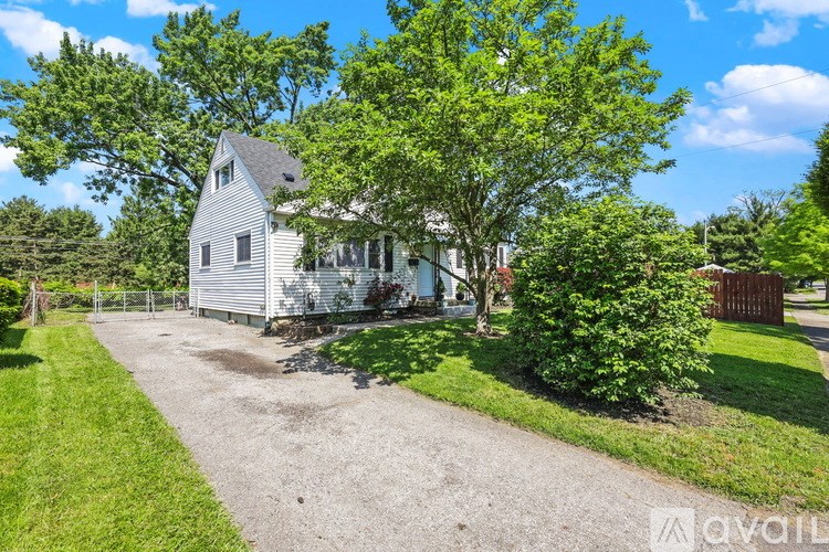 A house with a gravel driveway and a green lawn.