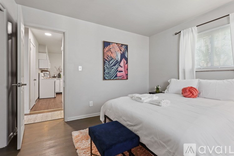 A bedroom with a large bed and a painting on the wall.