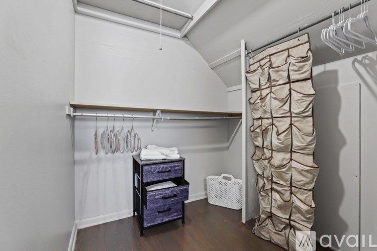 A room with a white wall and a brown shelf.