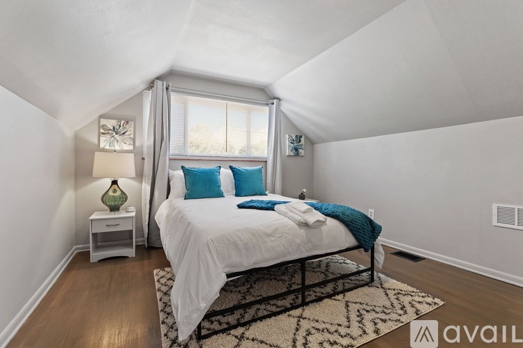 A bedroom with a bed, nightstand, and window.