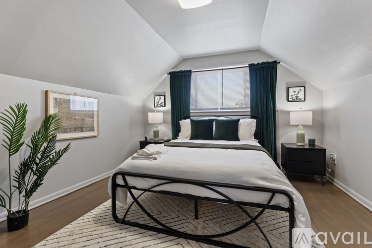 A bedroom with a large bed and a plant.