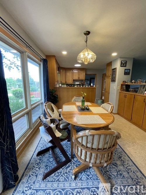 A dining room with a table set for two and a view of the backyard.