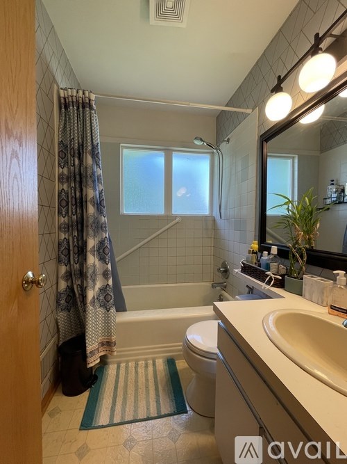 A bathroom with a toilet, sink, and shower.