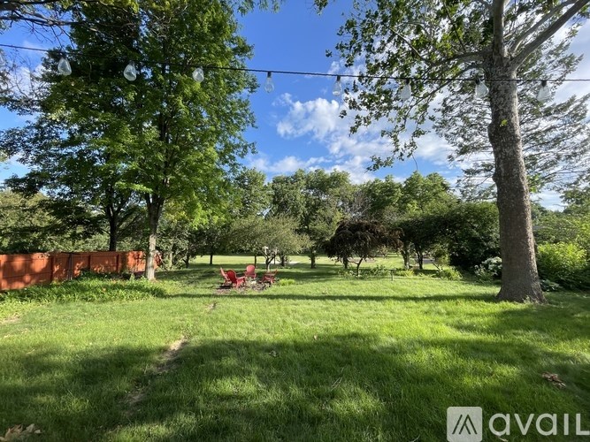 A grassy field with trees and a picnic table.