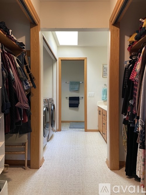 A hallway with a washer and dryer in the background.